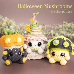 May include: Three crocheted Halloween mushroom plushies. One is a pumpkin, one is a mushroom with a green and yellow hat, and one is a mushroom with a pink and green hat. The mushrooms have cute faces and are all smiling.