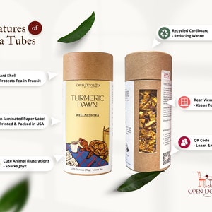May include: Two brown cardboard tea tubes with a clear window showing the tea inside. The tube on the left has a label that says "OPEN DOOR TEA TURMERIC DAWN WELLNESS TEA". The tube on the right has a label that says "OPEN DOOR TEA".