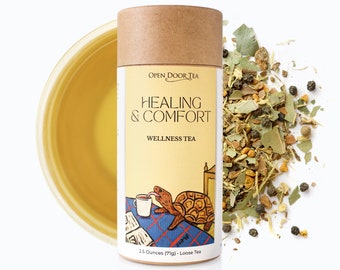May include: A brown cardboard tube with a yellow label that reads "OPEN DOOR TEA HEALING & COMFORT WELLNESS TEA". The label also features an illustration of a turtle drinking tea in bed. The tube contains 2.5 ounces (71g) of loose leaf tea.