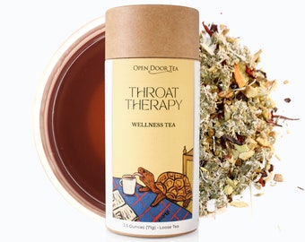 May include: A brown cardboard tube with a yellow label that says "OPEN DOOR TEA" and "THROAT THERAPY WELLNESS TEA". The label also features a cartoon illustration of a turtle drinking tea. The tube contains 2.5 ounces (7g) of loose tea.