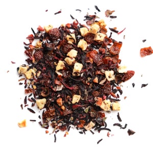May include: A close-up of a blend of dried fruit and herbs for tea. The mix includes dried apple pieces, hibiscus flowers, and other red berries.