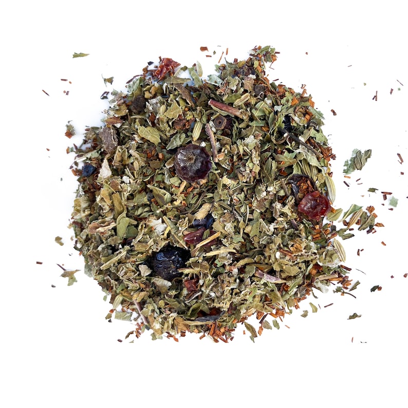 May include: A close-up of a loose leaf tea blend with dried herbs, berries, and flower petals. The tea blend is a mix of green, brown, and red colors.