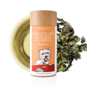 May include: A brown cardboard tube with a white label that says "OPEN DOOR TEA" and "ANXI-OOLONG GOLDEN FLOWER OOLONG TEA". The label also features a cartoon dog drinking tea. The tube contains 2.5 ounces (71g) of loose tea.