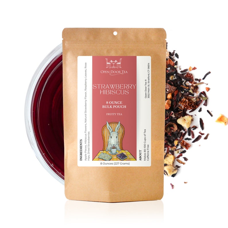 May include: A brown paper pouch with a white label that says "Strawberry Hibiscus" and "8 Ounce Bulk Pouch Fruity Tea". The label also has a cartoon rabbit sitting in a chair and reading a book. The pouch is open and there is a pile of loose leaf tea on a white background.