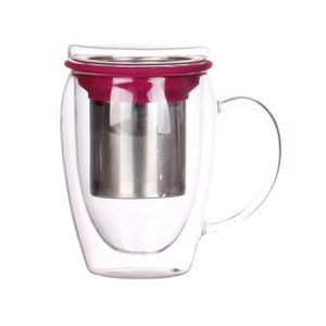 Op de afbeelding: Een heldere glazen theemok met een handvat, voorzien van een roestvrijstalen infuser en een diep magenta deksel. Het dubbelwandige ontwerp houdt dranken warm. De mok is ontworpen voor het zetten van losse thee.