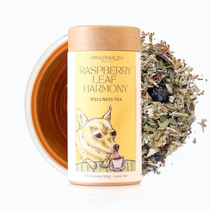 May include: A yellow and brown tube of loose leaf tea with a cartoon dog on the front. The label reads "Open Door Tea Raspberry Leaf Harmony Wellness Tea 1.75 Ounces (50g) Loose Tea".