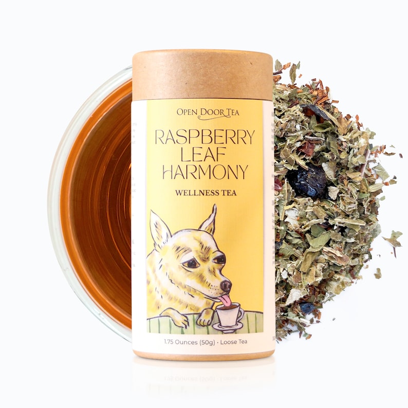 May include: A yellow and brown tube of loose leaf tea with a cartoon dog on the front. The label reads "Open Door Tea Raspberry Leaf Harmony Wellness Tea 1.75 Ounces (50g) Loose Tea".