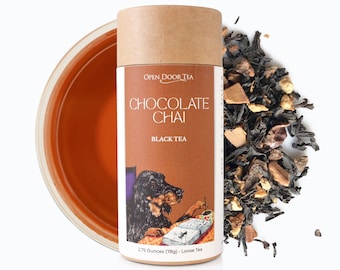May include: A brown cardboard tube with a label that reads "OPEN DOOR TEA CHOCOLATE CHAI BLACK TEA 2.75 Ounces (78g) Loose Tea". The label features a cartoon illustration of a dog reading a book. A pile of loose leaf tea is scattered around the tube.