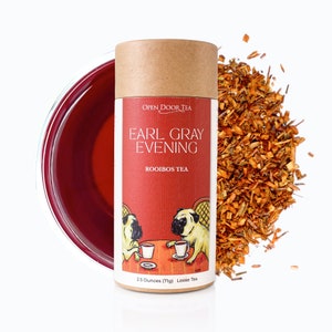 May include: A brown cardboard tube with a red label that says "OPEN DOOR TEA EARL GRAY EVENING ROOIBOS TEA" and features two pugs drinking tea. The label also says "2.5 Ounces (71g) Loose Tea".