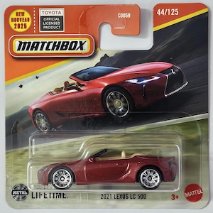 Puede incluir: Un modelo Matchbox de un descapotable Lexus LC 500 de 2021 en color rojo oscuro. El embalaje incluye el logotipo de Matchbox, el producto con licencia oficial de Toyota y el texto "NEW NOUVEAU 2025". El modelo está marcado 44/125.