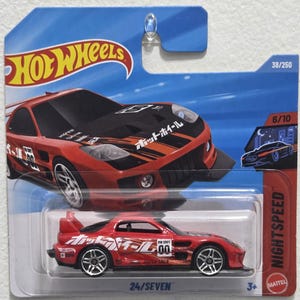 Könnte beinhalten: Ein rotes und schwarzes Hot Wheels Spielzeugauto mit dem Text "Hot Wheels" und japanischem Text auf der Verpackung. Das Auto ist ein Sportwagen mit dem Text "HW Drift" und der Nummer "00" an der Seite. Die Verpackung trägt auch die Aufschrift "NIGHTSPEED" und "24/SEVEN".