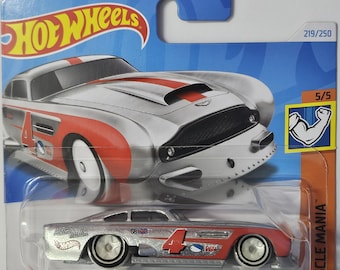 May include: A silver and red die-cast toy car model of an Aston Martin DB4GT High-Speed Edition. The car has a number 4 on the side and is part of the Hot Wheels Muscle Mania series.