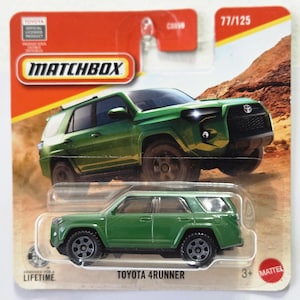 May include: A green Toyota 4Runner die-cast toy vehicle in its original Matchbox blister packaging. The card features an illustration of the SUV on a desert trail, the Matchbox logo, the text 77/125, and the Toyota official licensed product label.