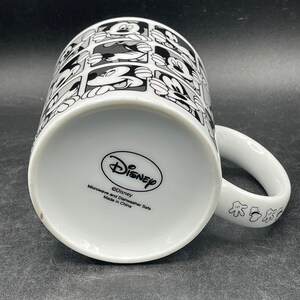 Pu&ograve; includere: Tazza in ceramica bianca con un design in bianco e nero di volti di Topolino. La tazza ha un manico nero e dice "Disney" sul fondo. Adatta per microonde e lavastoviglie. Prodotto in Cina.