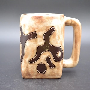 May include: A square-shaped ceramic mug with a handle, featuring a beige and brown color scheme. The mug is adorned with dark brown abstract shapes. The mug is suitable for hot or cold beverages.