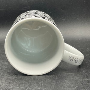 Pu&ograve; includere: Tazza in ceramica bianca con un design bianco e nero di mani di Topolino sul manico e un design bianco e nero di teste di Topolino sul lato della tazza.