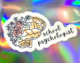 May include: A white sticker featuring a stylized brain illustration with floral accents in pink and green. The words "school psychologist" are written in black script, adding a professional touch to the design.