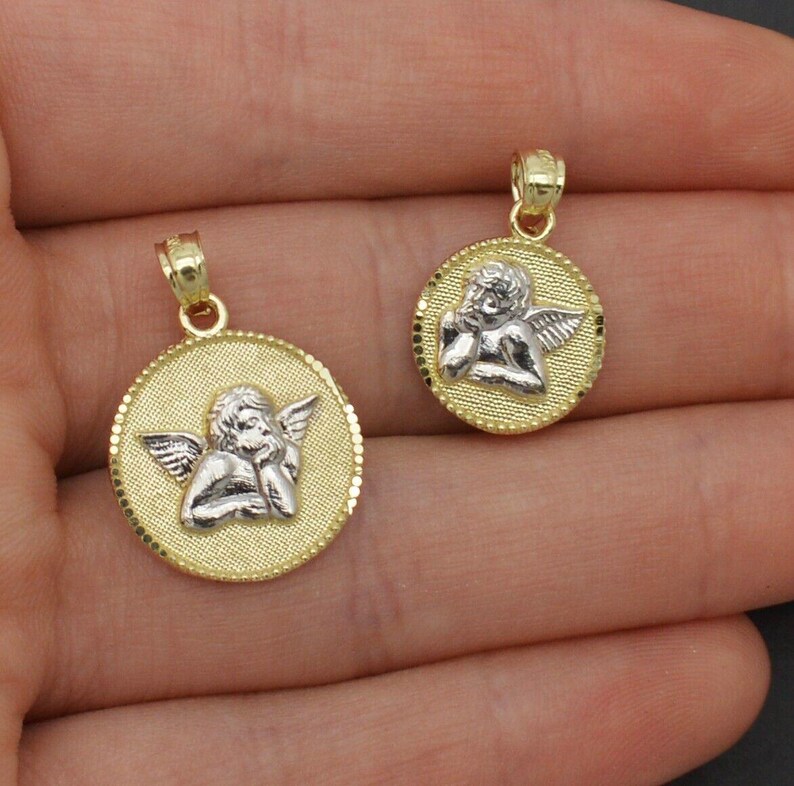 May include: Two gold angel pendant necklaces with a white angel design. The larger pendant is about 1 inch in diameter and the smaller pendant is about 3/4 inch in diameter.