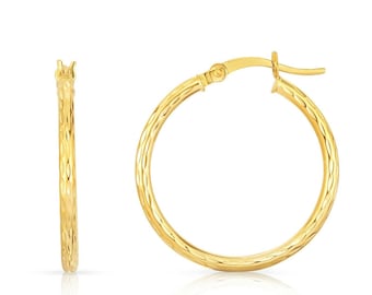 May include: A pair of gold hoop earrings with a textured finish. The earrings are made of 14k gold and have a diameter of 1 inch.