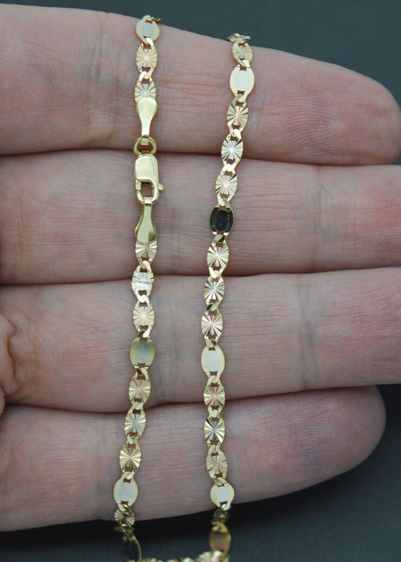 May include: A gold chain necklace with a diamond-cut design. The chain is made of three different colours of gold: yellow, white, and rose.