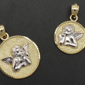 May include: Two gold angel pendant necklaces. The pendants are round and feature a detailed image of an angel with wings. The angel is made of silver and is set against a gold background.