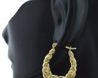 May include: Gold hoop earrings with a textured design and a star-shaped detail. The earrings are shown on a black mannequin head.