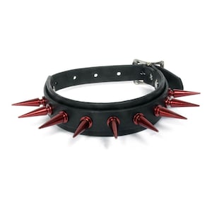 May include: Black leather choker with red metal spikes. The choker has a buckle closure.