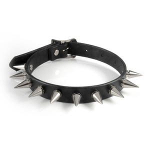 May include: A black collar featuring a series of evenly spaced, pointed silver-toned metal spikes attached to the band. The accessory includes a metal buckle closure with a single prong and a matching metal loop to secure the end of the strap.