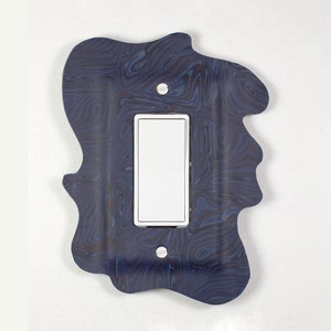 May include: A blue and black marbled light switch cover with a white light switch.