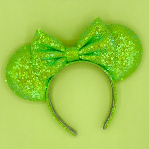 May include: Lime green sequined Minnie Mouse ears headband with a large bow.