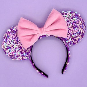 May include: Purple and pink sequined mouse ears headband with a pink velvet bow.
