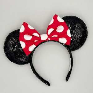 May include: Black sequined Minnie Mouse ears with a red and white polka dot bow.