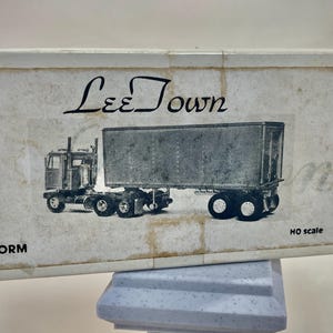 May include: A black and white illustration of a semi-truck and trailer with the text "Lee Town" and "Kit Form" on a white background.