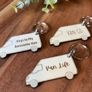 May include: Three wooden van keychains with different sayings. The first keychain says "Keys to My Awesome Van". The second keychain says "Van Go". The third keychain says "Van Life".