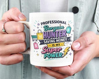 May include: White ceramic mug with the text "PROFESSIONAL BARGAIN HUNTER SAVING MONEY IS MY SUPER POWER" in colorful lettering. The mug features shopping-themed graphics like a shopping cart, a shopping bag, and a price tag.