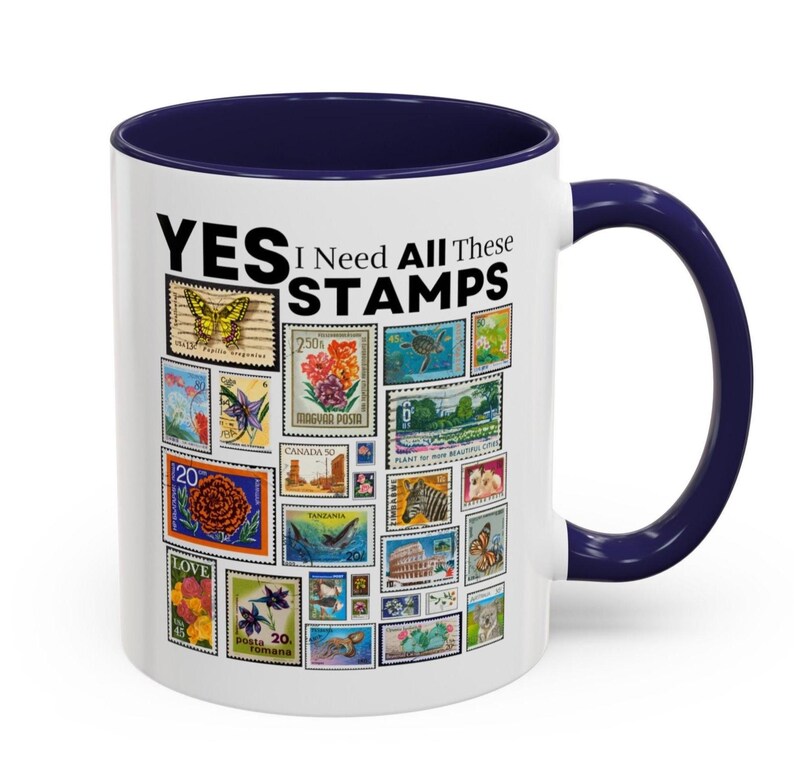 May include: White ceramic mug with a navy blue interior and handle. The mug is decorated with various colorful postage stamps and the text "YES I Need All These STAMPS". A great gift for stamp collectors.