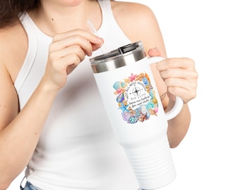 May include: White travel mug with a handle and a black lid. The mug features a colorful design of seashells, starfish, and the text "Not all who wander are lost. Some are looking for cool shells."