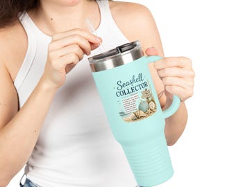 May include: A light blue travel mug with a handle and a silver lid. The mug features the text "Seashell Collector" with a definition and beach-themed illustrations. A clear straw is inserted into the lid.