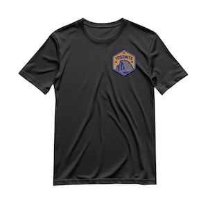 Puede incluir: Camiseta negra con un parche azul y naranja que dice "Yosemite" con un gráfico de montaña en su interior.