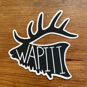 May include: Black and white sticker of an elk head with the word "WAPITI" written in white inside the head.