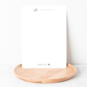 Peut inclure: Une carte blanche avec un petit papillon gris et le texte "www.herzensmomente-design.etsy.com" en haut. Le bas de la carte porte le texte "DANKE VON" suivi d'un petit c&oelig;ur brun.
