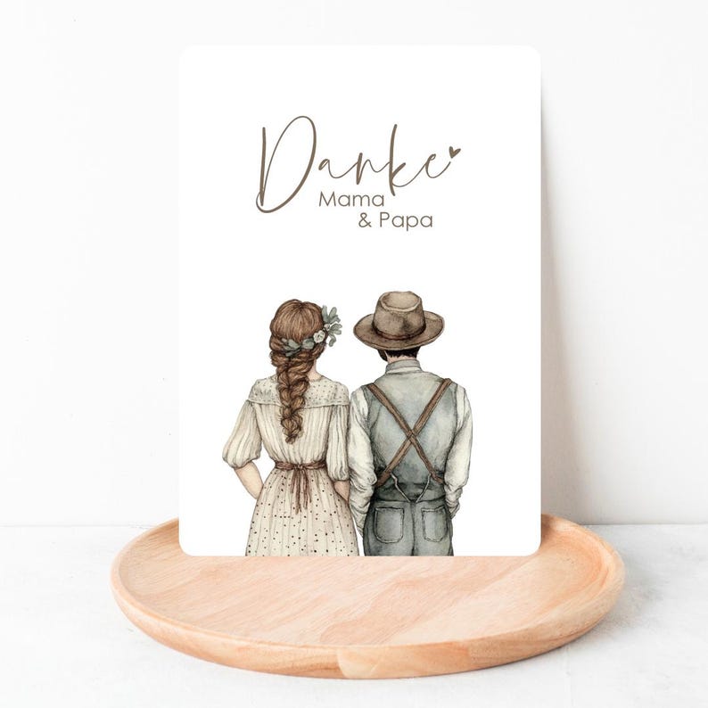 Peut inclure: Une carte blanche avec le texte "Danke Mama & Papa" en lettres brunes. La carte pr&eacute;sente une illustration aquarelle d'un couple debout dos &agrave; dos. La femme porte une robe blanche avec une couronne de fleurs et l'homme porte un chapeau brun et une chemise bleue.