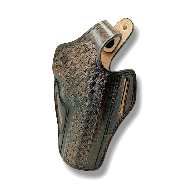 Pode incluir: Uma coldre de couro castanho com um padr&atilde;o de tecido de cesta. O coldre tem uma presilha para cinto e um recorte para uma arma de fogo. O couro &eacute; castanho escuro com detalhes em castanho claro.