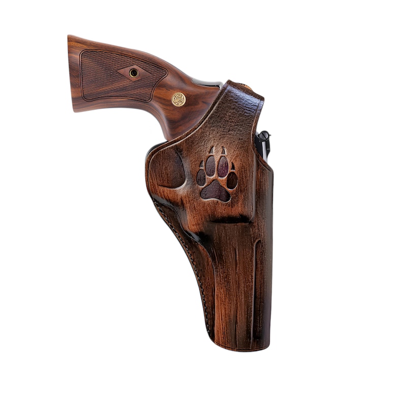 K&ouml;nnte beinhalten: Ein braunes Lederholster mit einem B&auml;renpfoten-Design. Das Holster ist f&uuml;r einen Revolver ausgelegt.