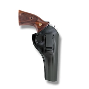 Peut inclure: Un étui en cuir noir avec un clip en métal, contenant un revolver avec une poignée en bois. La poignée du revolver est de couleur marron foncé avec un emblème doré. L'étui est conçu pour être porté à la ceinture.