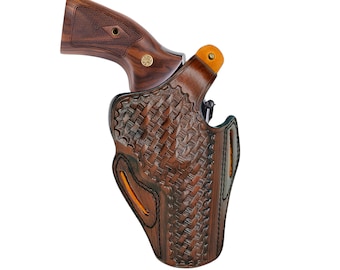 Könnte beinhalten: Ein braunes Lederholster mit einem gewebten Korbgeflechtmuster, das einen Revolver mit einem Holzgriff hält. Das Holster hat orangefarbene Akzente und schwarze Nähte. Der Griff des Revolvers ist dunkles Holz mit einem goldenen Emblem.