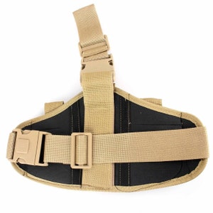 May include: Tan tactical thigh holster with adjustable straps and a quick-release buckle. The holster features a black interior and is designed to secure a firearm. The leg strap is adjustable for a comfortable fit. The holster is made of durable nylon.