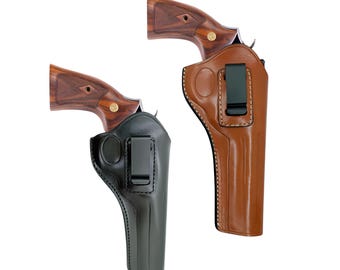 Könnte beinhalten: Zwei Leder-Pistolenholster, eines in Schwarz und eines in Braun, die jeweils einen Revolver halten. Die Holster haben einen Clip zur Befestigung am Gürtel. Die Revolver haben Holzgriffe mit einem goldenen Emblem.
