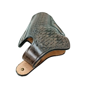 Pode incluir: Uma coldre de couro castanho escuro com um padr&atilde;o de tecido de cesta. O coldre tem uma forma curva com uma presilha de cinto e um rebite de lat&atilde;o. O interior &eacute; de cor castanho claro.