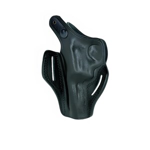 Op de afbeelding: Een zwarte leren holster met een gevormd ontwerp. De holster heeft een gebogen vorm met een lus aan de bovenkant en verschillende openingen aan de zijkanten. Het leer lijkt glad te zijn en heeft een glanzende afwerking. De holster is ontworpen om een vuurwapen te bevatten.